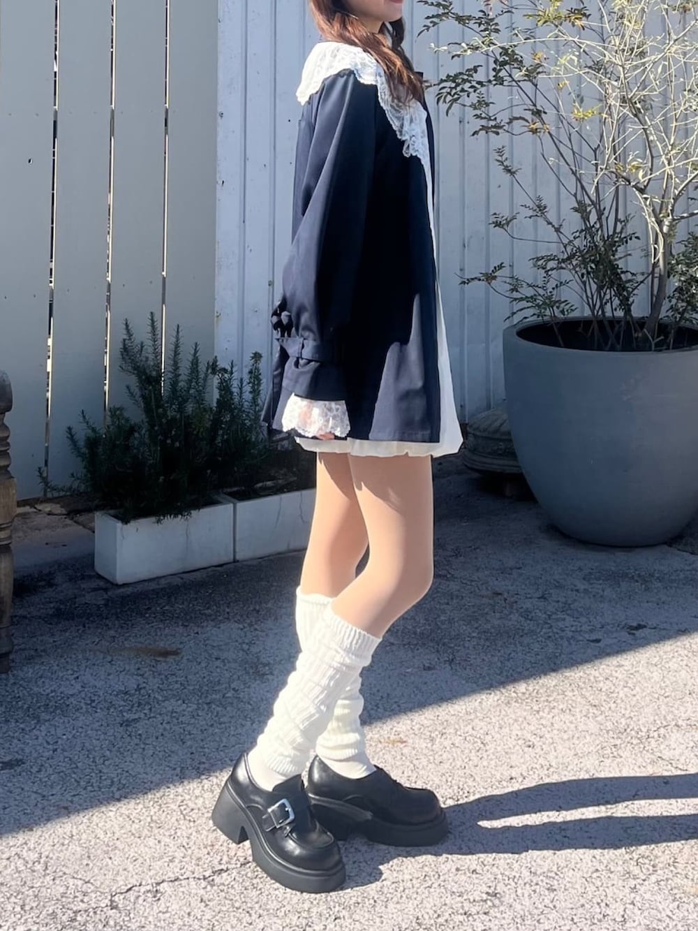 ブルー系のトレンチコート、イエロー系のカーディガン/ボレロを着用したレディースの冬コーディネートの2枚目の写真