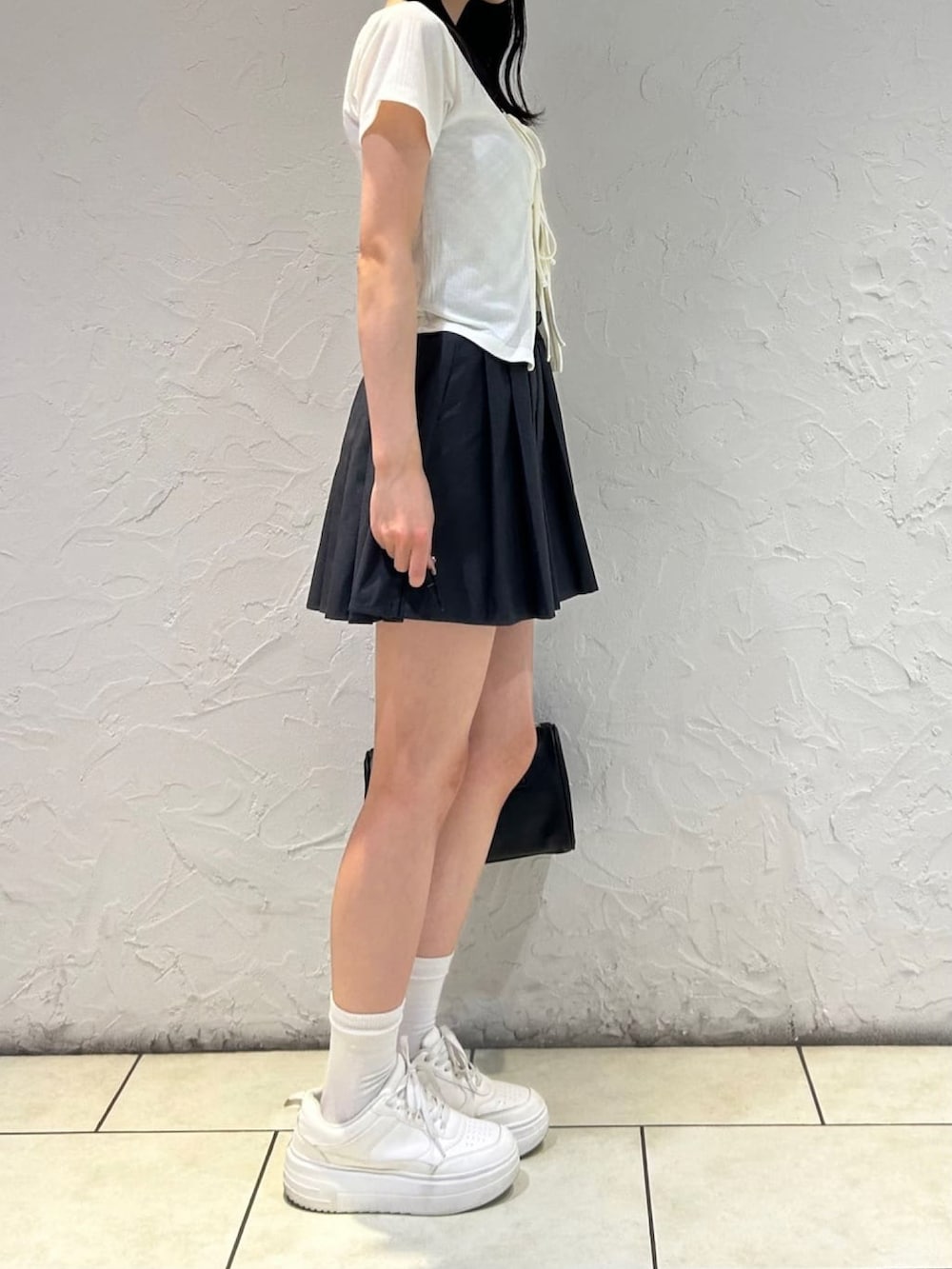 グレー系のスカート、ホワイト系のアンサンブルを着用したレディースの夏コーディネートの2枚目の写真