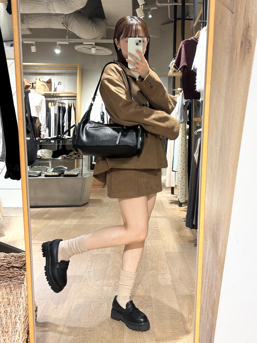 イエロー系のテーラードジャケット、イエロー系のスカート、ブラック系のローファーを着用したレディースの秋コーディネートの2枚目の写真