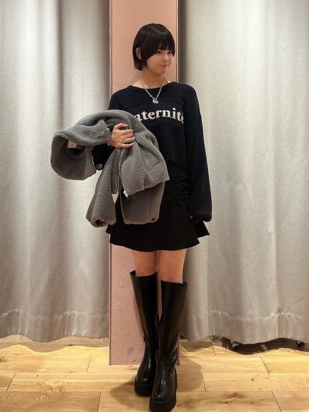 ホワイト系のブルゾン、ホワイト系のニット/セーター、ブラック系のスカートを着用したレディースの冬コーディネートの2枚目の写真