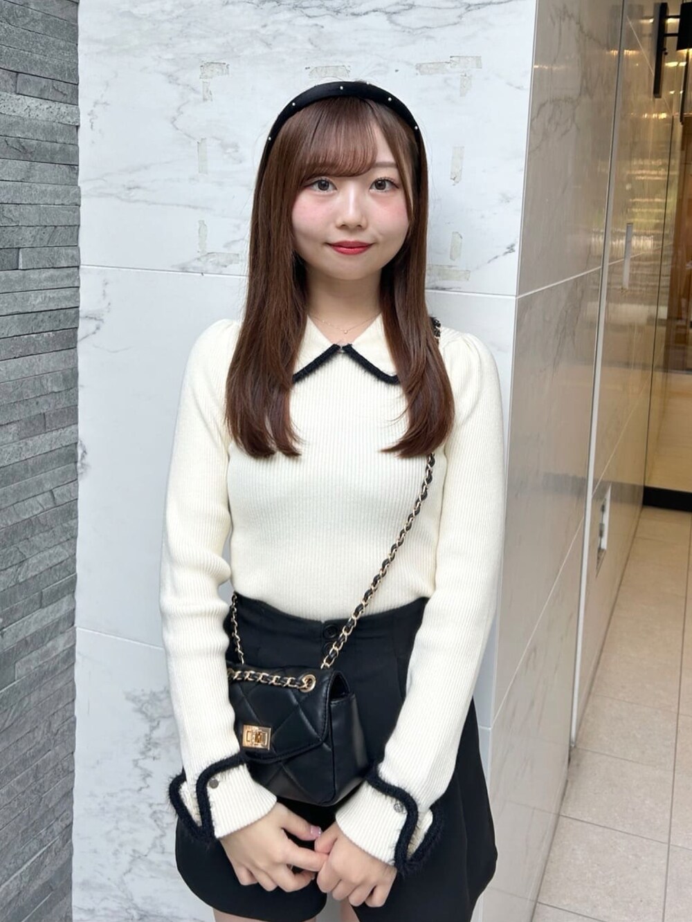 ホワイト系のニット/セーター、ブラック系のその他パンツを着用したレディースの冬コーディネートの2枚目の写真