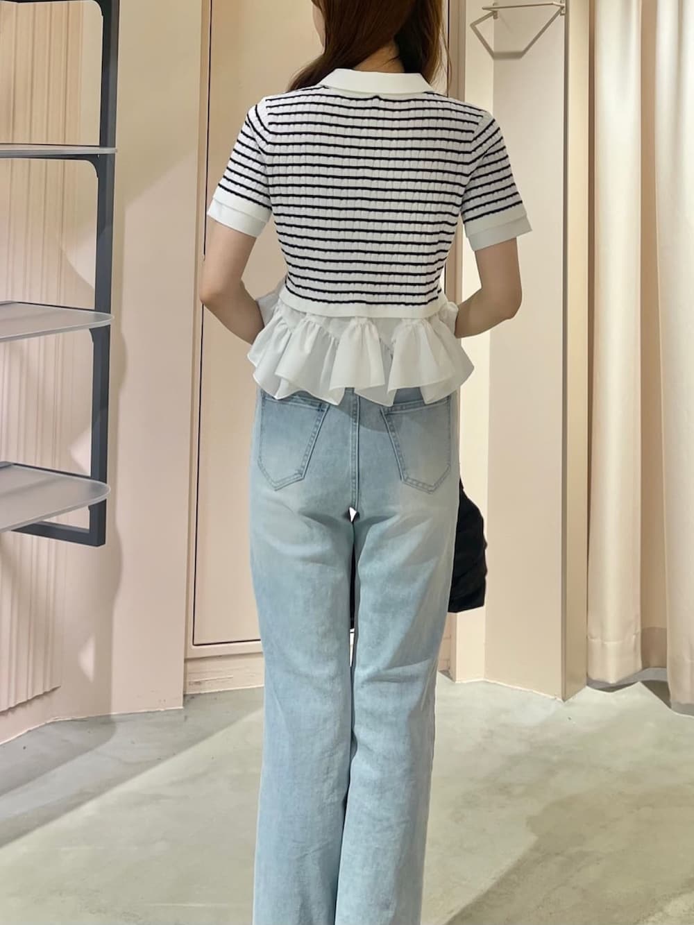 ホワイト系のニット/セーター、ブルー系のデニムパンツを着用したレディースの春コーディネートの3枚目の写真