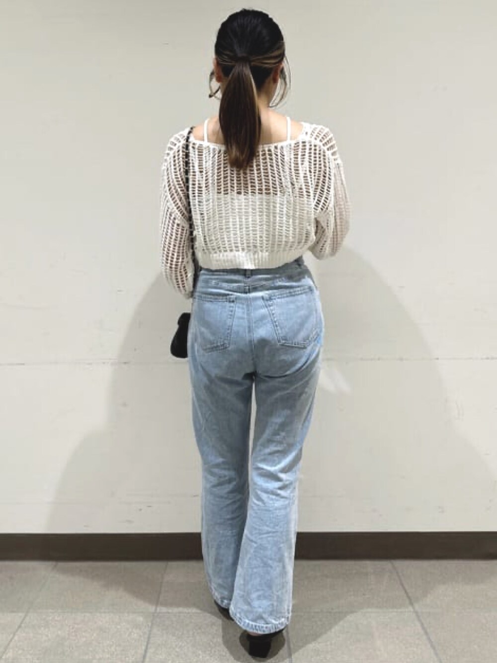 ホワイト系のニット/セーター、ブルー系のデニムパンツを着用したレディースの夏コーディネートの2枚目の写真