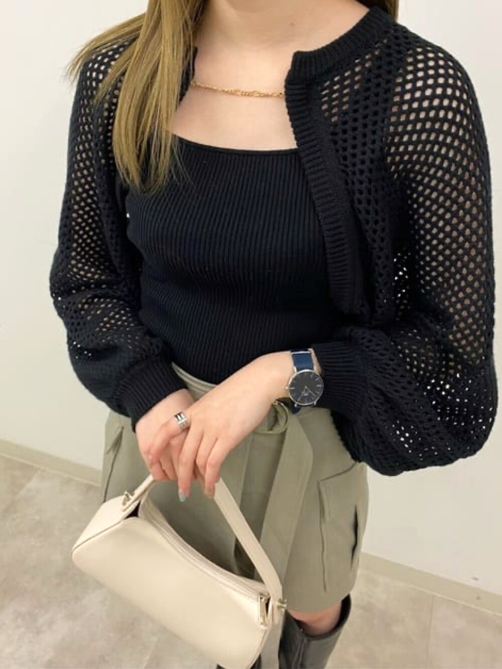 ブラック系のニット/セーター、ベージュ系のスカート、ホワイト系のハンドバッグを着用したレディースの冬コーディネートの3枚目の写真