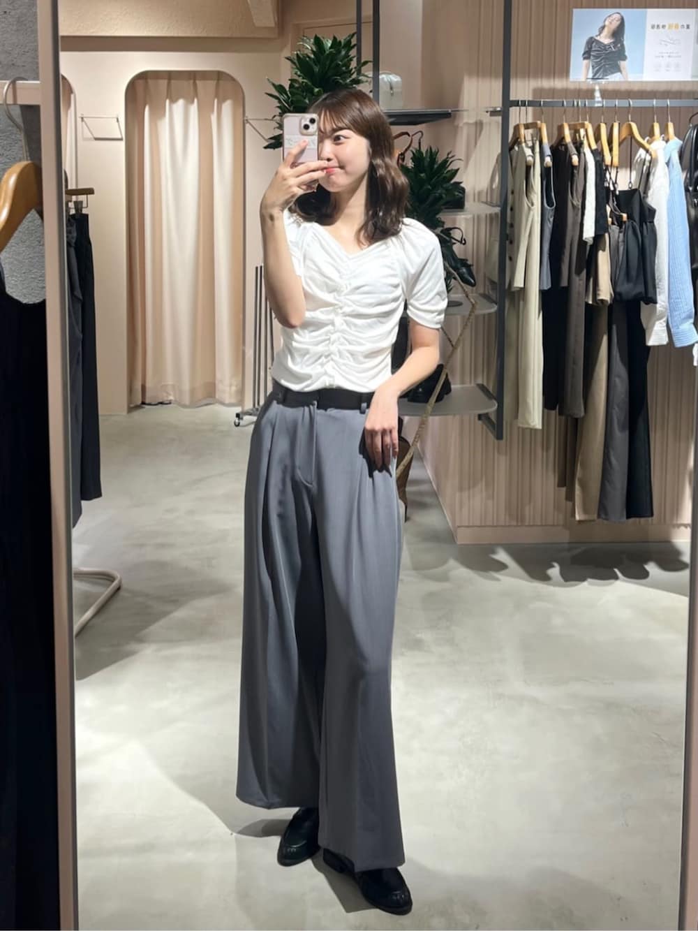 グレー系のスラックス、ブラック系のローファー、ホワイト系のTシャツ/カットソーを着用したレディースの夏コーディネートの2枚目の写真