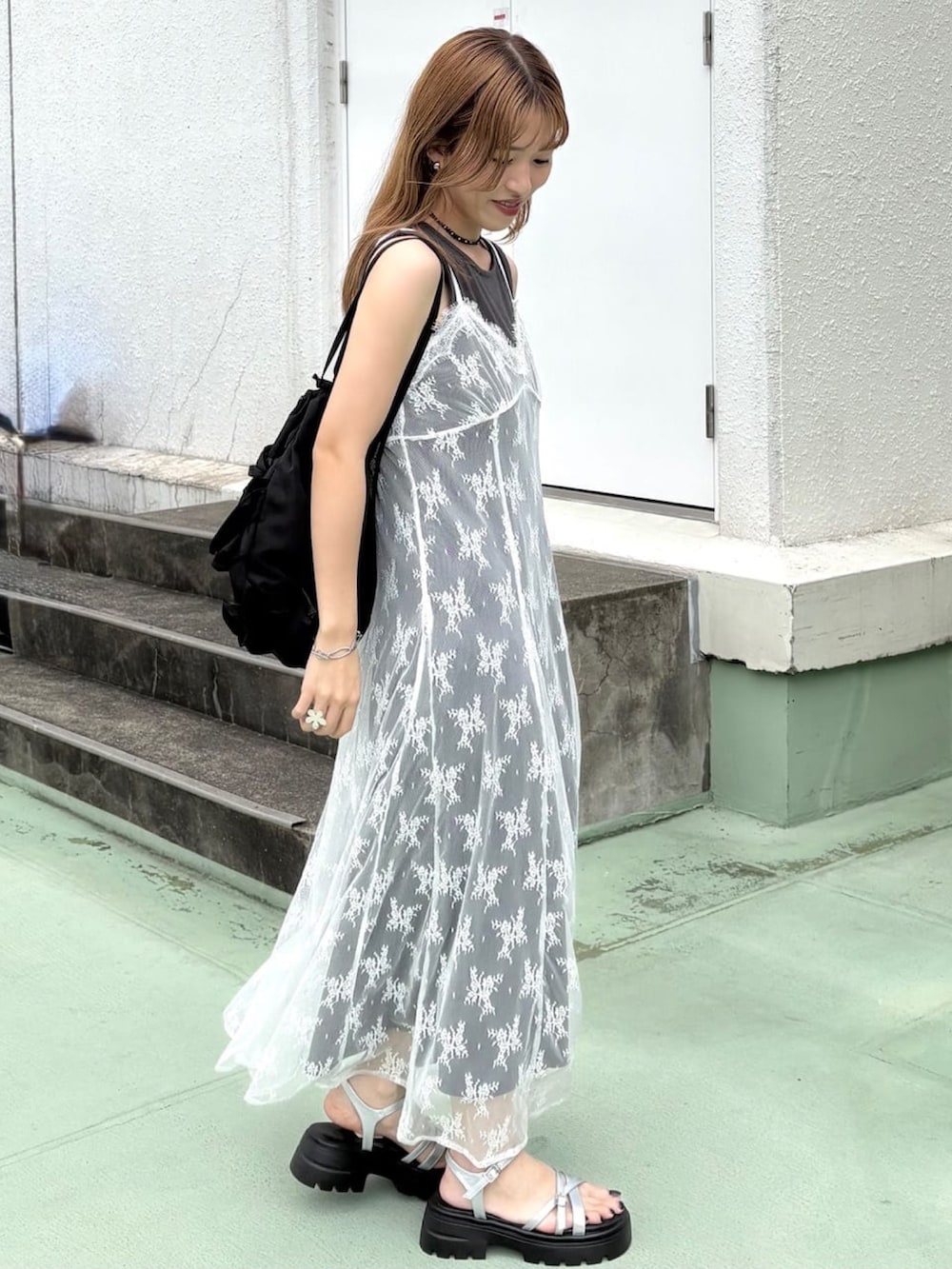 グレー系のワンピース、ブラック系のショルダーバッグ、グレー系のサンダルを着用したレディースの夏コーディネートの2枚目の写真