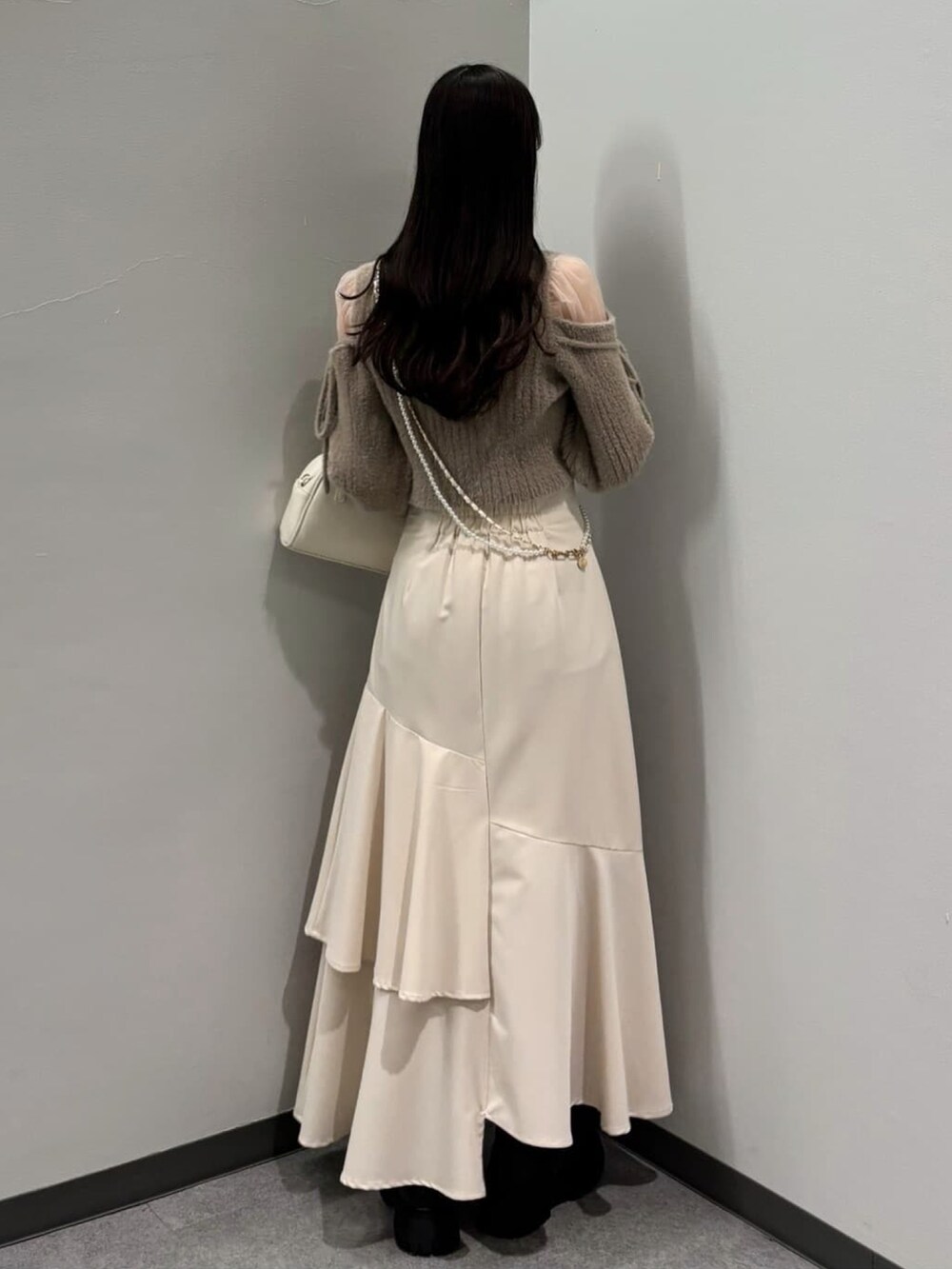 ピンク系のニット/セーター、ホワイト系のスカートを着用したレディースの冬コーディネートの2枚目の写真