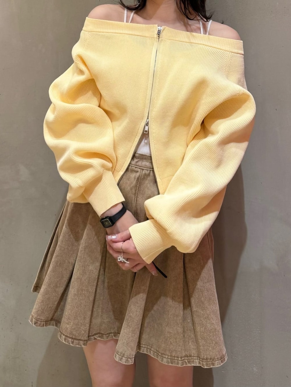 ベージュ系のスカート、ブラウン系のショルダーバッグ、イエロー系のニット/セーターを着用したレディースの冬コーディネートの2枚目の写真