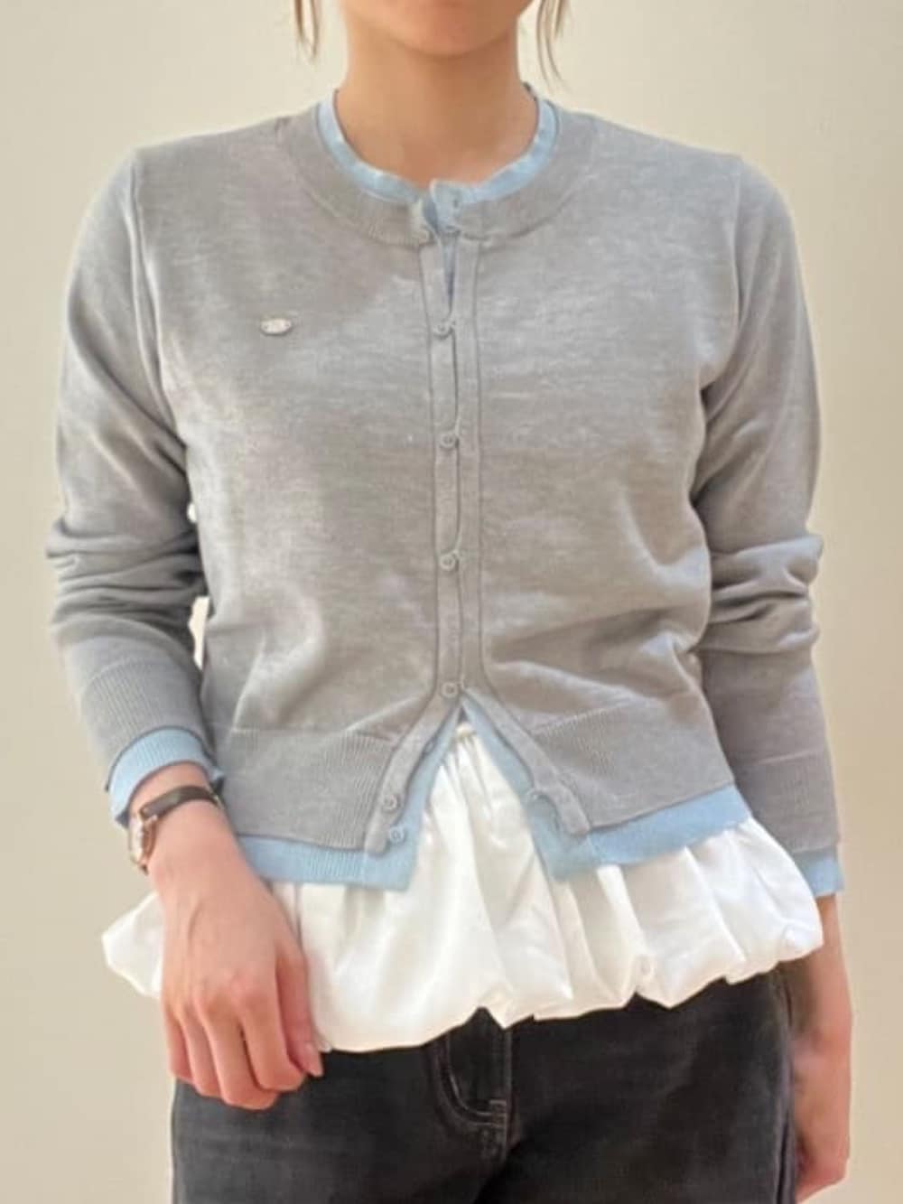 グレー系のカーディガン/ボレロ、ホワイト系のキャミソール、ブラック系のデニムパンツを着用したレディースの秋コーディネートの3枚目の写真