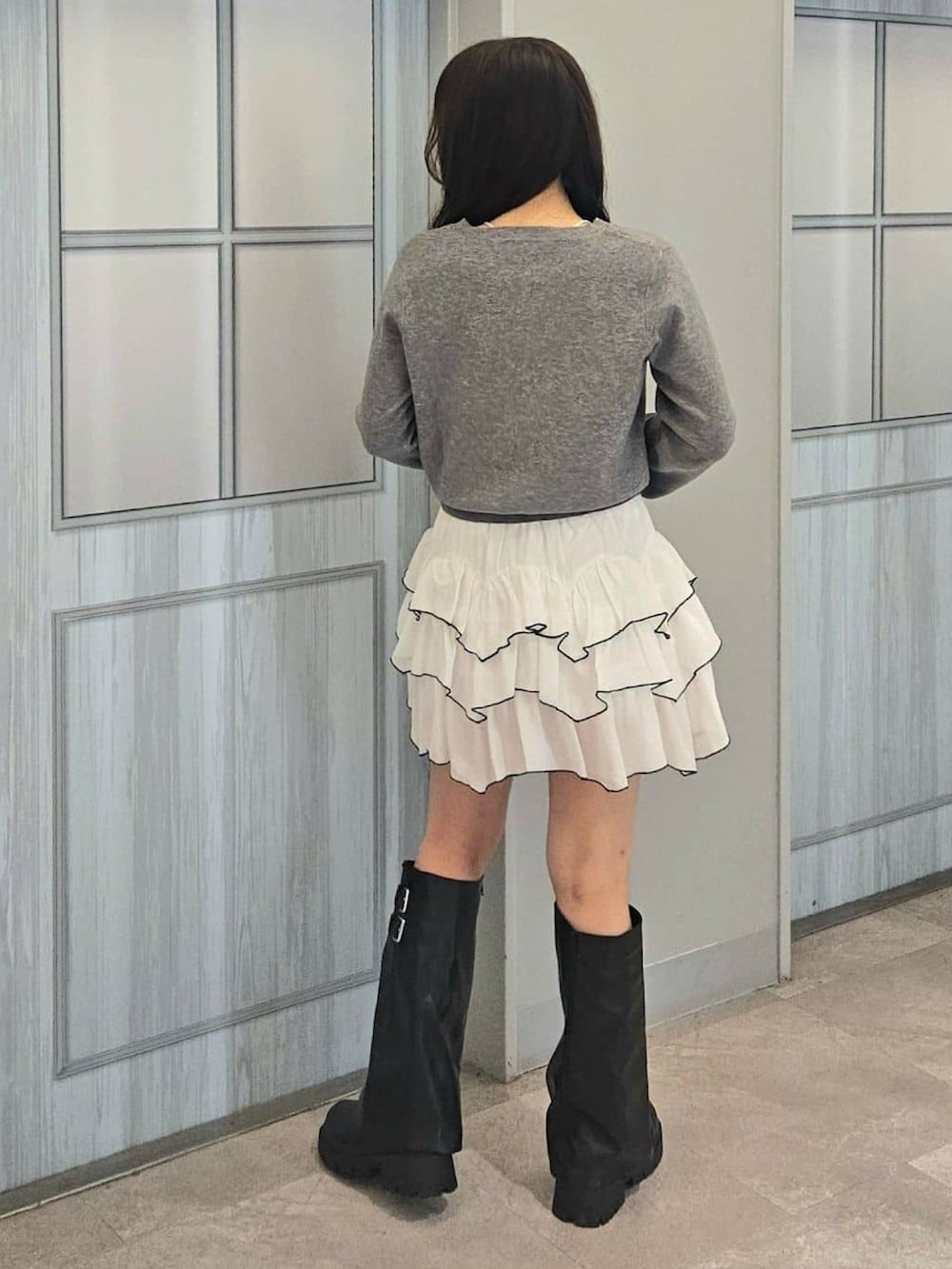 グレー系のニット/セーター、ホワイト系のスカート、ブラック系のボストンバッグを着用したレディースの秋コーディネートの2枚目の写真