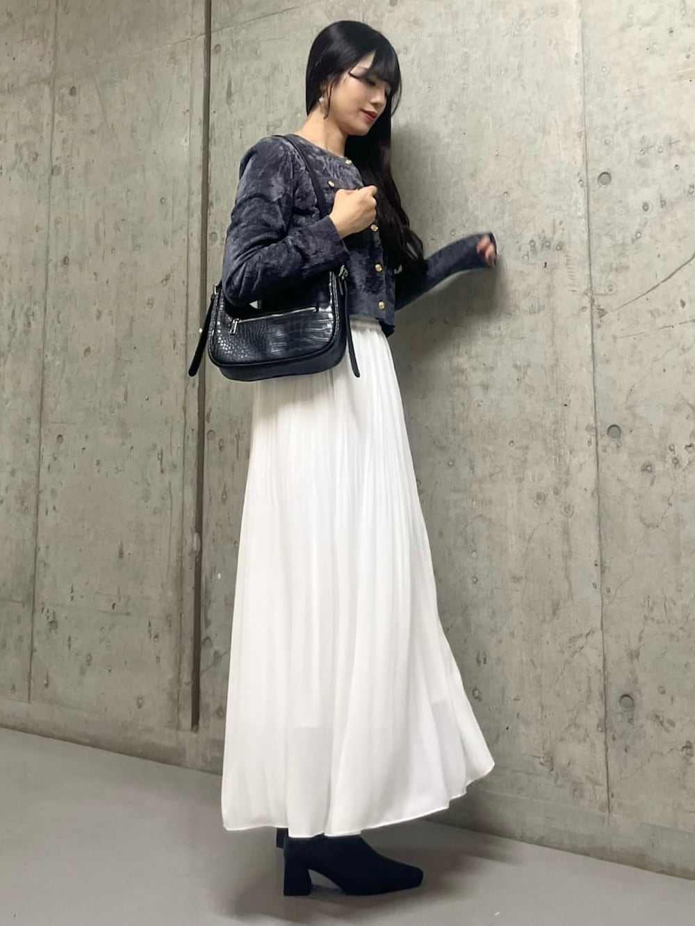 グレー系のカーディガン/ボレロ、ホワイト系のスカートを着用したレディースの秋コーディネートの2枚目の写真