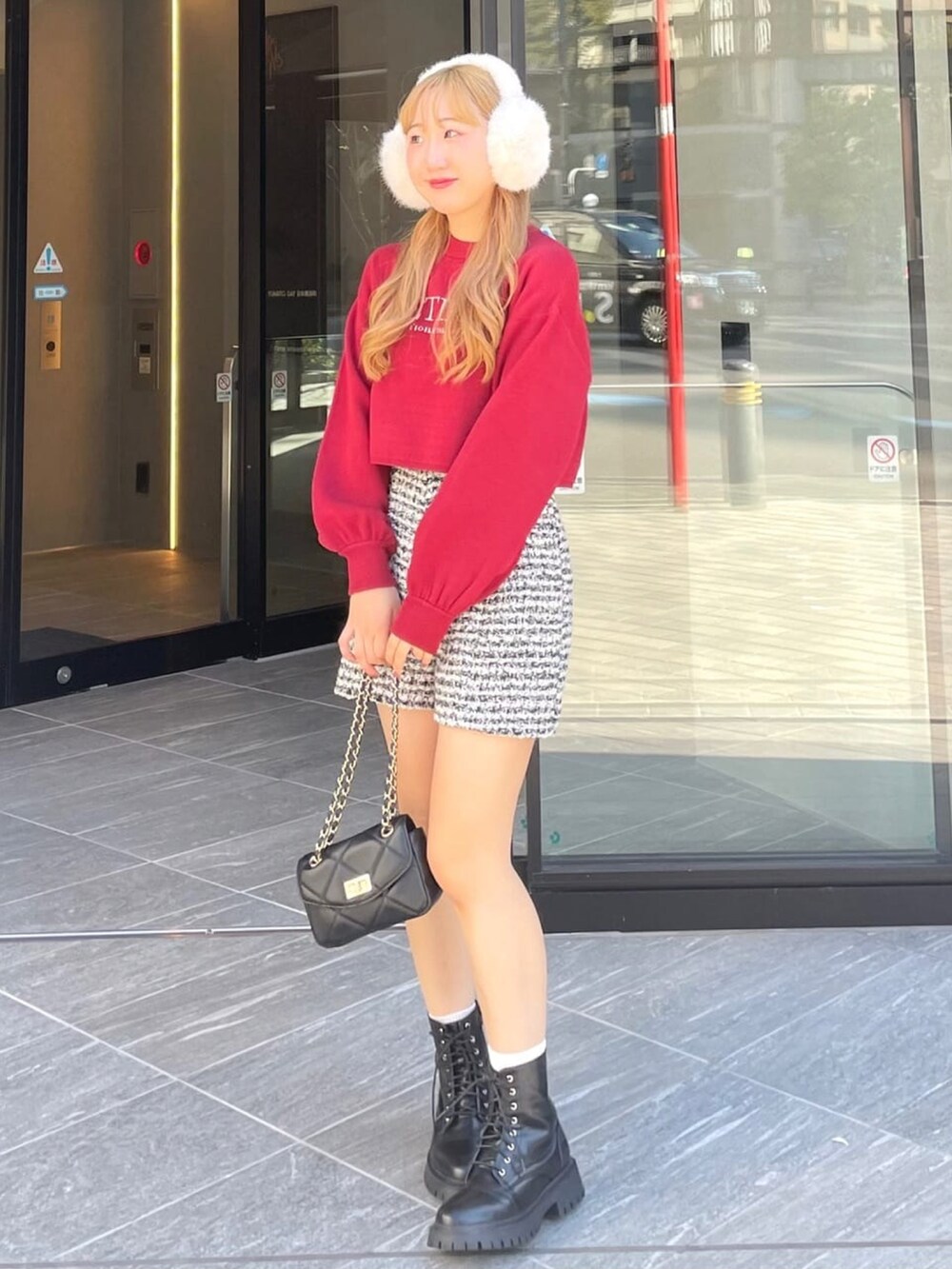 レッド系のニット/セーター、ホワイト系のその他パンツ、ブラック系のブーツを着用したレディースの冬コーディネートの2枚目の写真