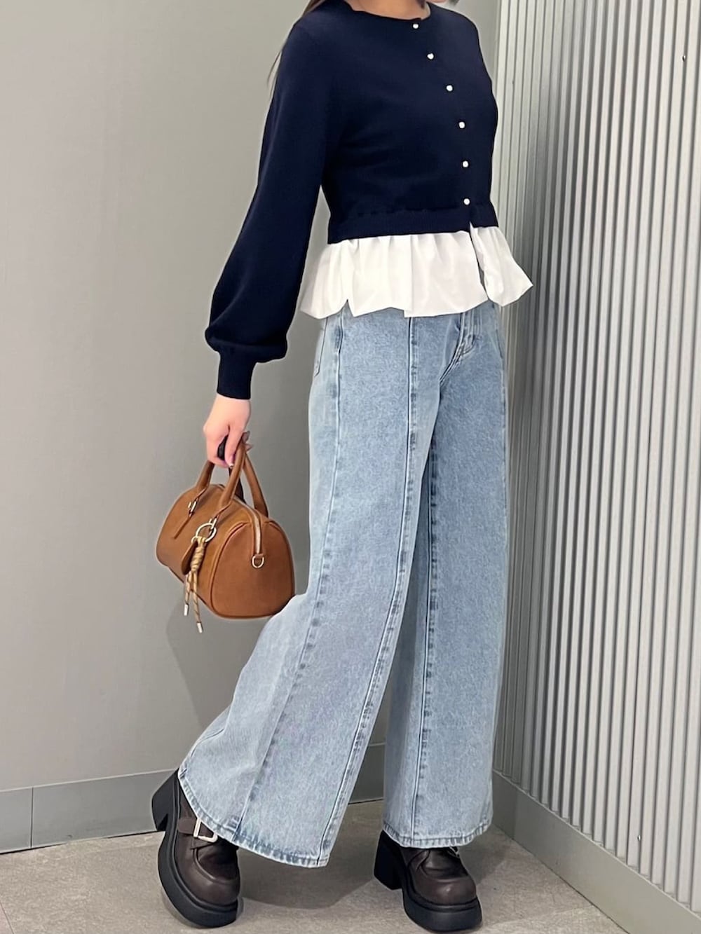 ブルー系のニット/セーター、ブルー系のデニムパンツを着用したレディースの冬コーディネートの2枚目の写真