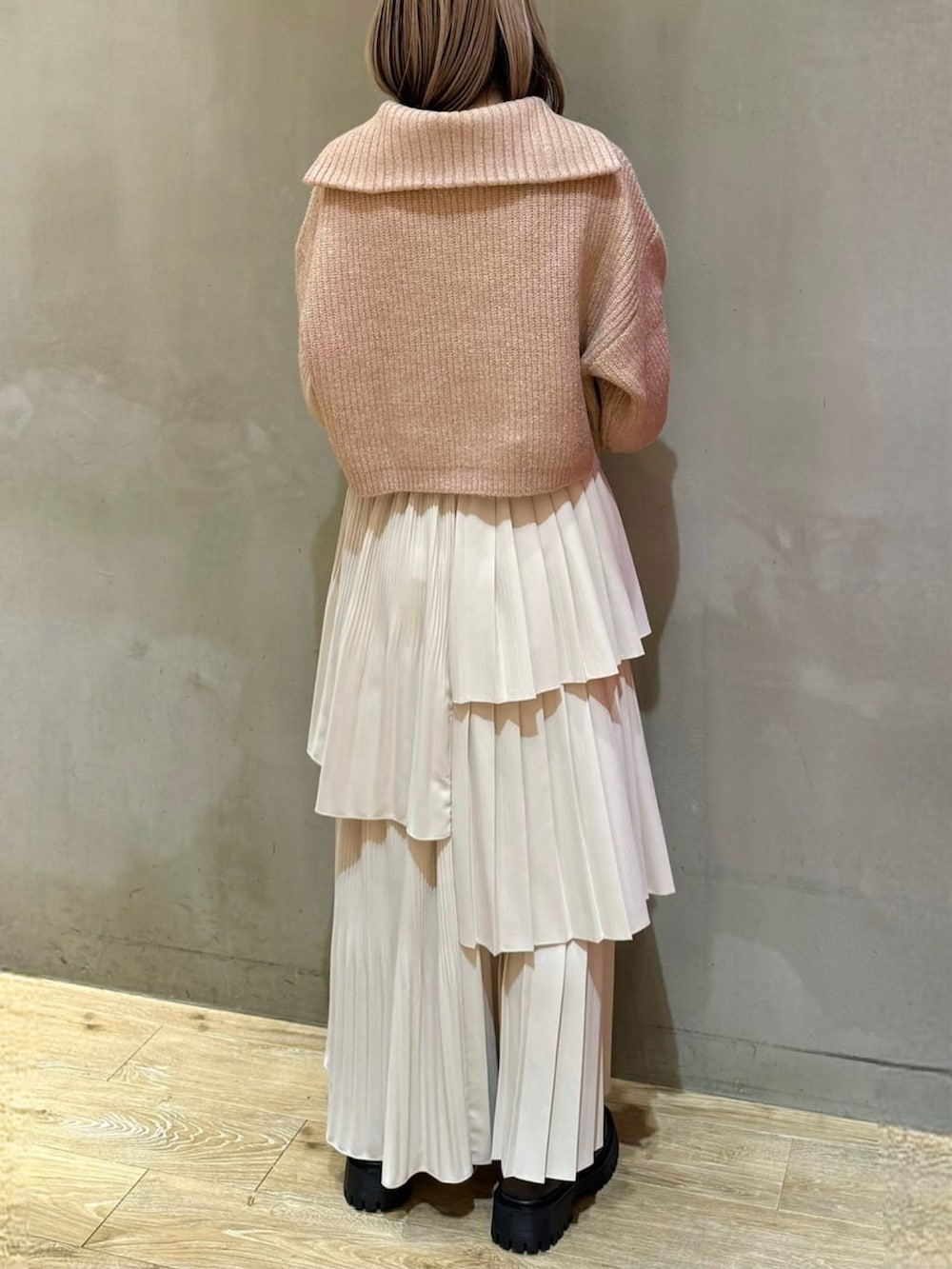 ホワイト系のスカート、ブラウン系のブーツ、ピンク系のニット/セーターを着用したレディースの冬コーディネートの2枚目の写真