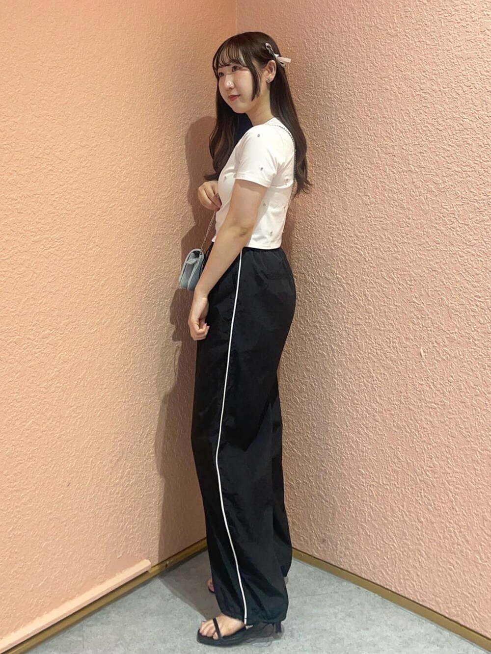 ホワイト系のTシャツ/カットソー、ホワイト系のカーゴパンツ、ブラック系のサンダルを着用したレディースの夏コーディネートの2枚目の写真