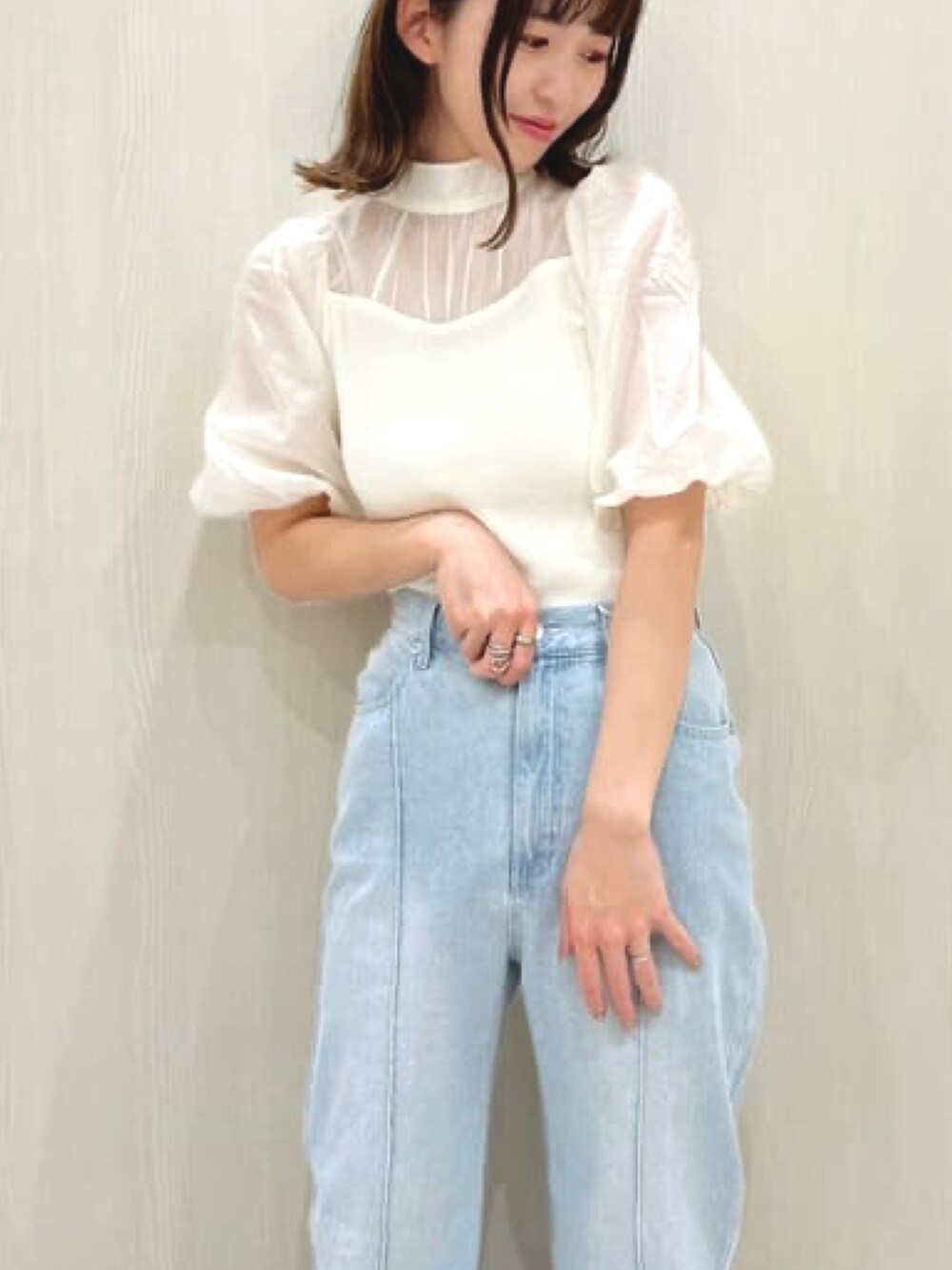 ホワイト系のニット/セーター、ブルー系のデニムパンツ、ホワイト系のサンダルを着用したレディースの春コーディネートの2枚目の写真