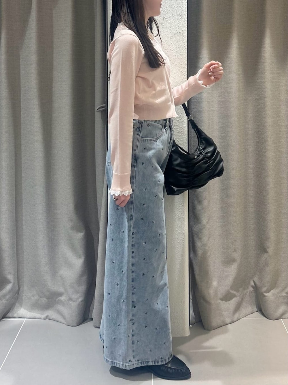 ピンク系のニット/セーター、ブルー系のデニムパンツを着用したレディースの春コーディネートの2枚目の写真