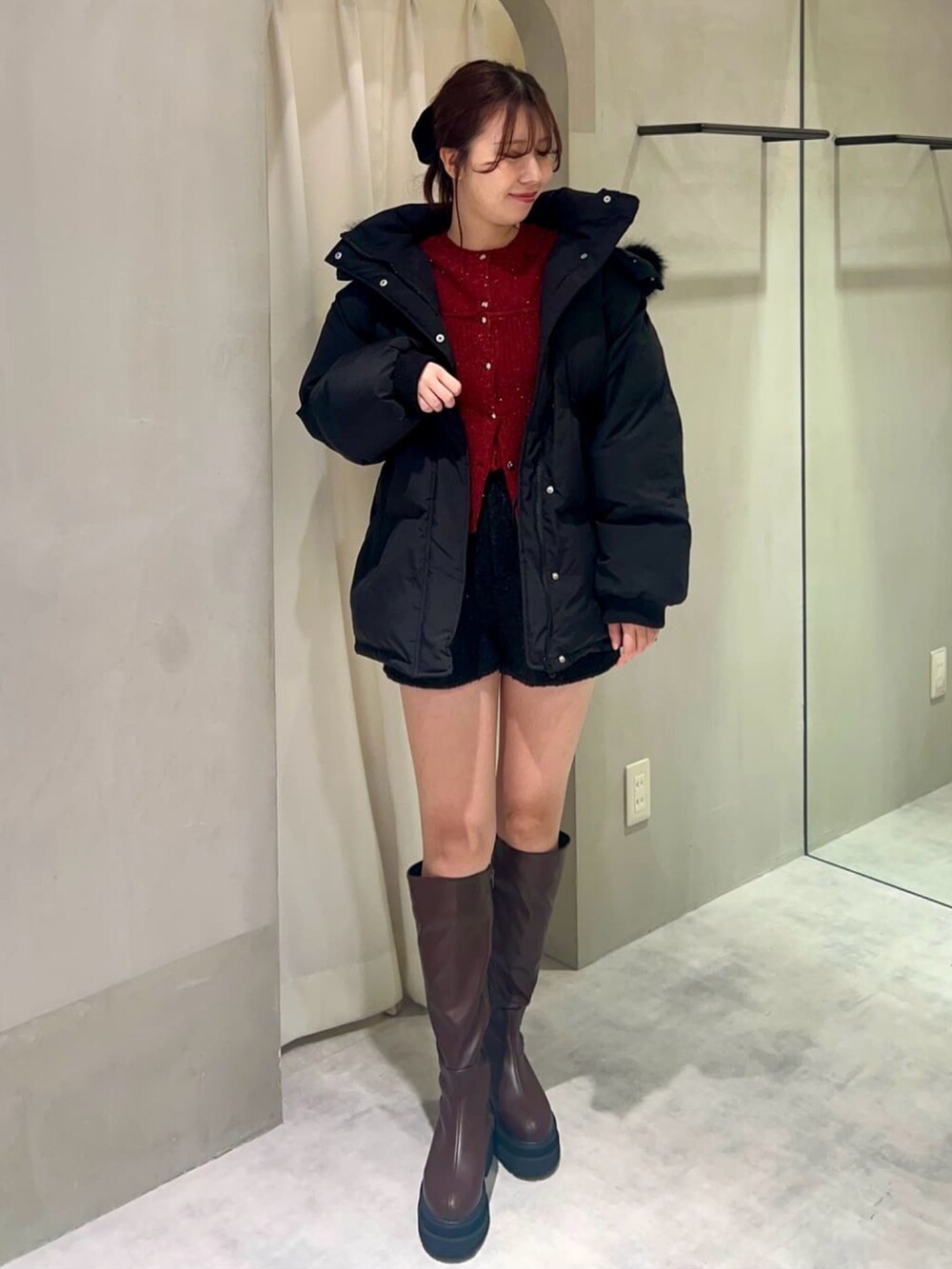 ブラック系のダウンジャケット/コート、ブラウン系のブーツ、グレー系のショルダーバッグを着用したレディースの冬コーディネートの2枚目の写真