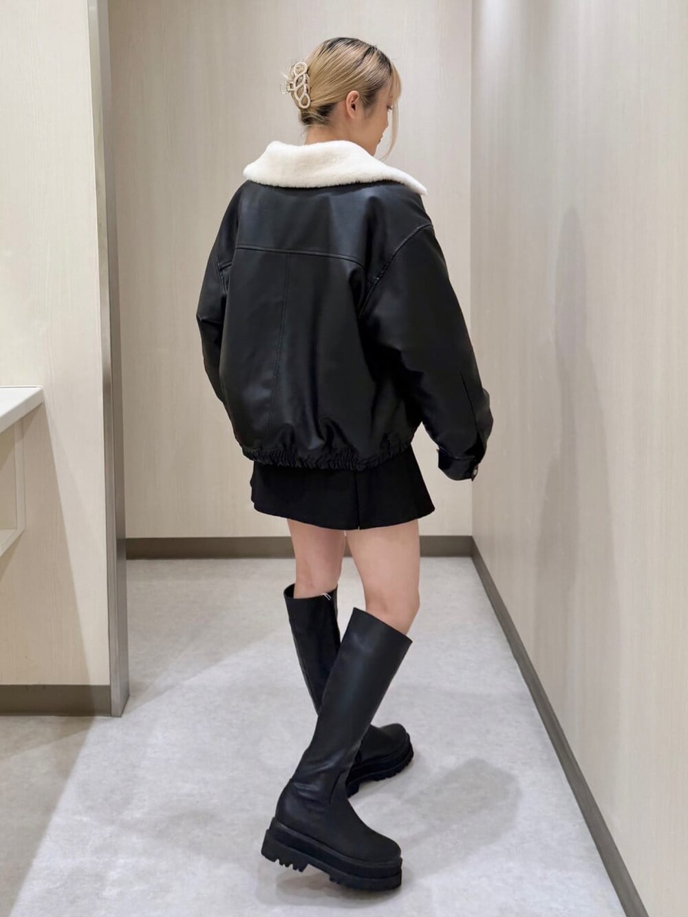 ブラック系のブルゾン、ピンク系のニット/セーター、ブラック系のスカートを着用したレディースの冬コーディネートの2枚目の写真