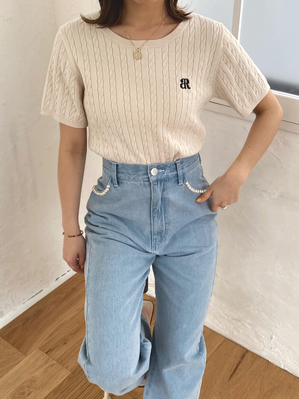 ホワイト系のニット/セーター、ブルー系のデニムパンツを着用したレディースの春コーディネートの3枚目の写真