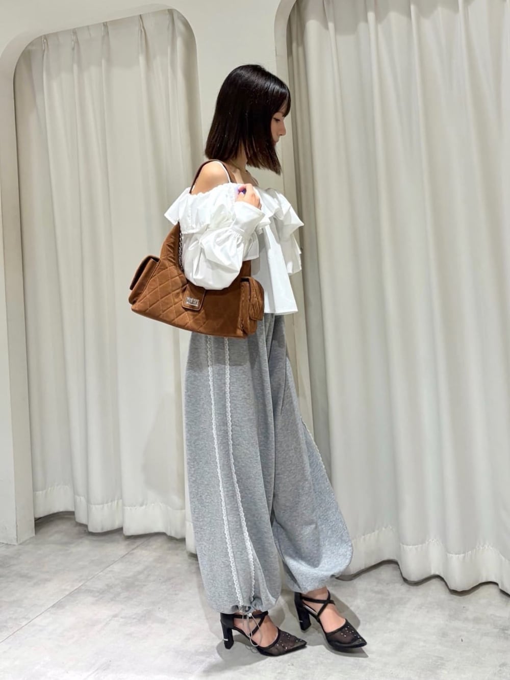 ホワイト系のシャツ/ブラウス、グレー系のスウェットパンツ、ブラウン系のショルダーバッグを着用したレディースの夏コーディネートの2枚目の写真