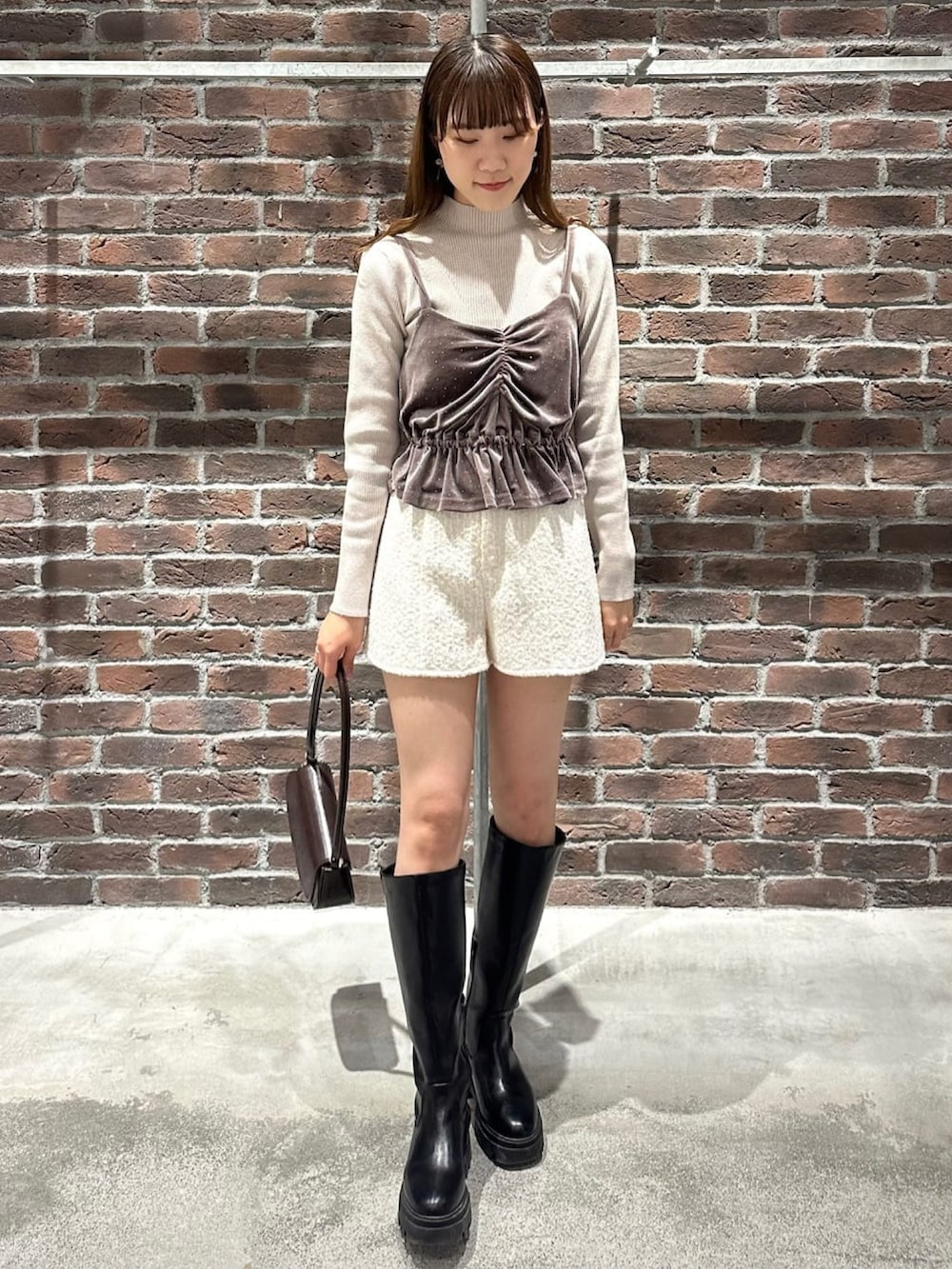 ホワイト系のショルダーバッグ、ブラック系のニット/セーター、ホワイト系のその他パンツを着用したレディースの冬コーディネートの3枚目の写真