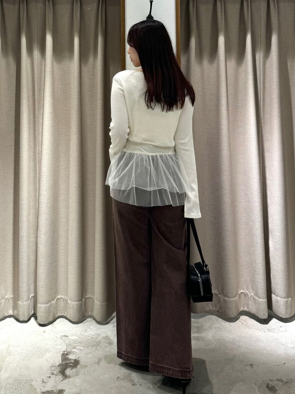 ホワイト系のアンサンブル、ブラウン系のデニムパンツ、ブラック系のパンプスを着用したレディースの夏コーディネートの3枚目の写真