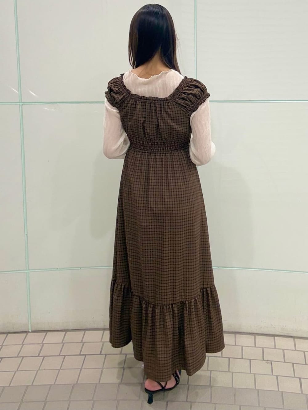 ブラウン系のワンピース、ホワイト系のTシャツ/カットソー、ブラック系のサンダルを着用したレディースの夏コーディネートの3枚目の写真