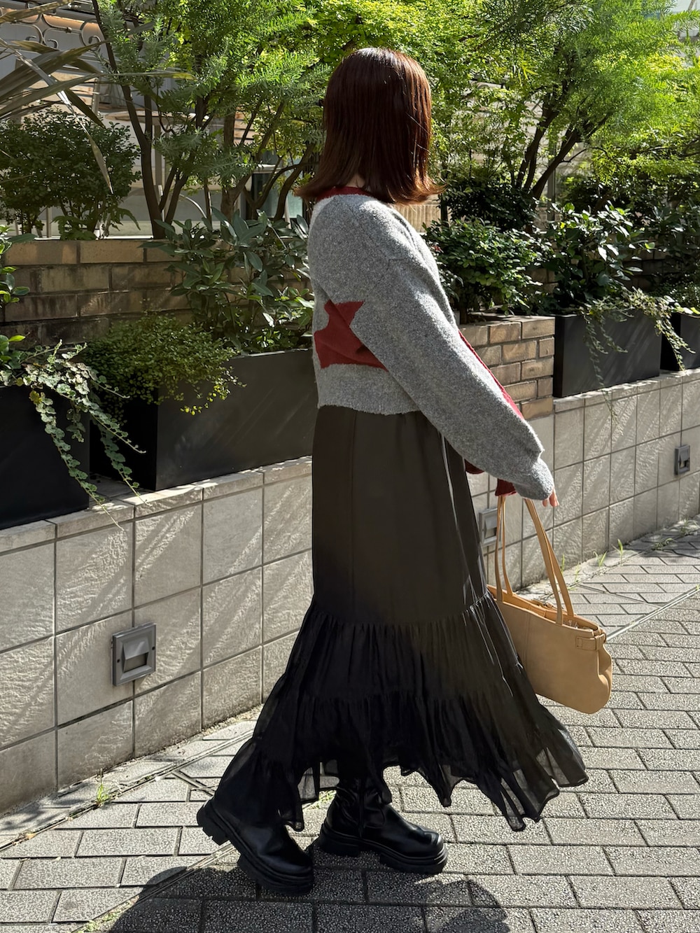 レッド系のTシャツ/カットソー、ブラック系のスカートを着用したレディースの秋コーディネートの2枚目の写真