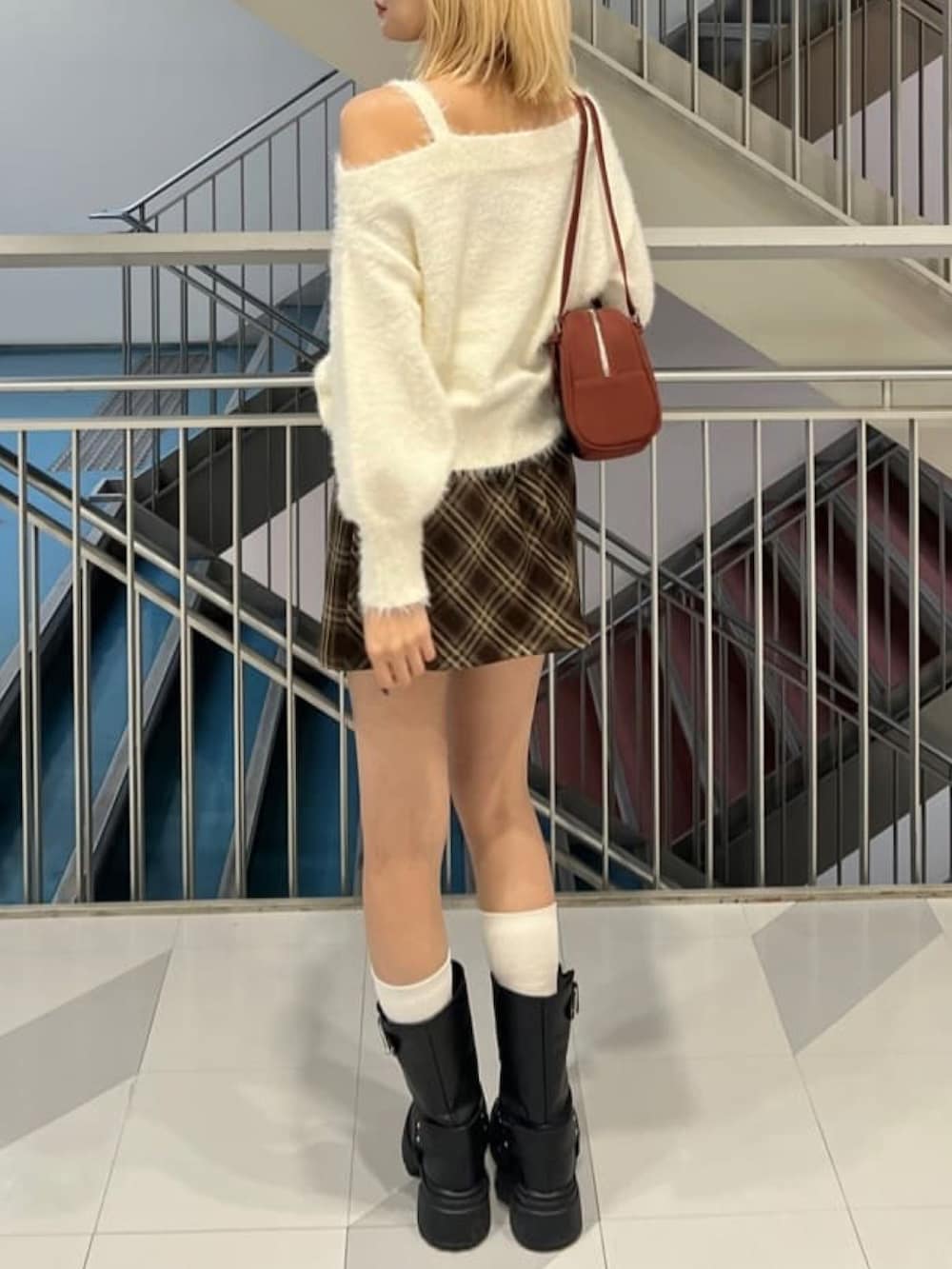 ホワイト系のニット/セーター、ブラウン系のスカート、レッド系のボストンバッグを着用したレディースの秋コーディネートの3枚目の写真