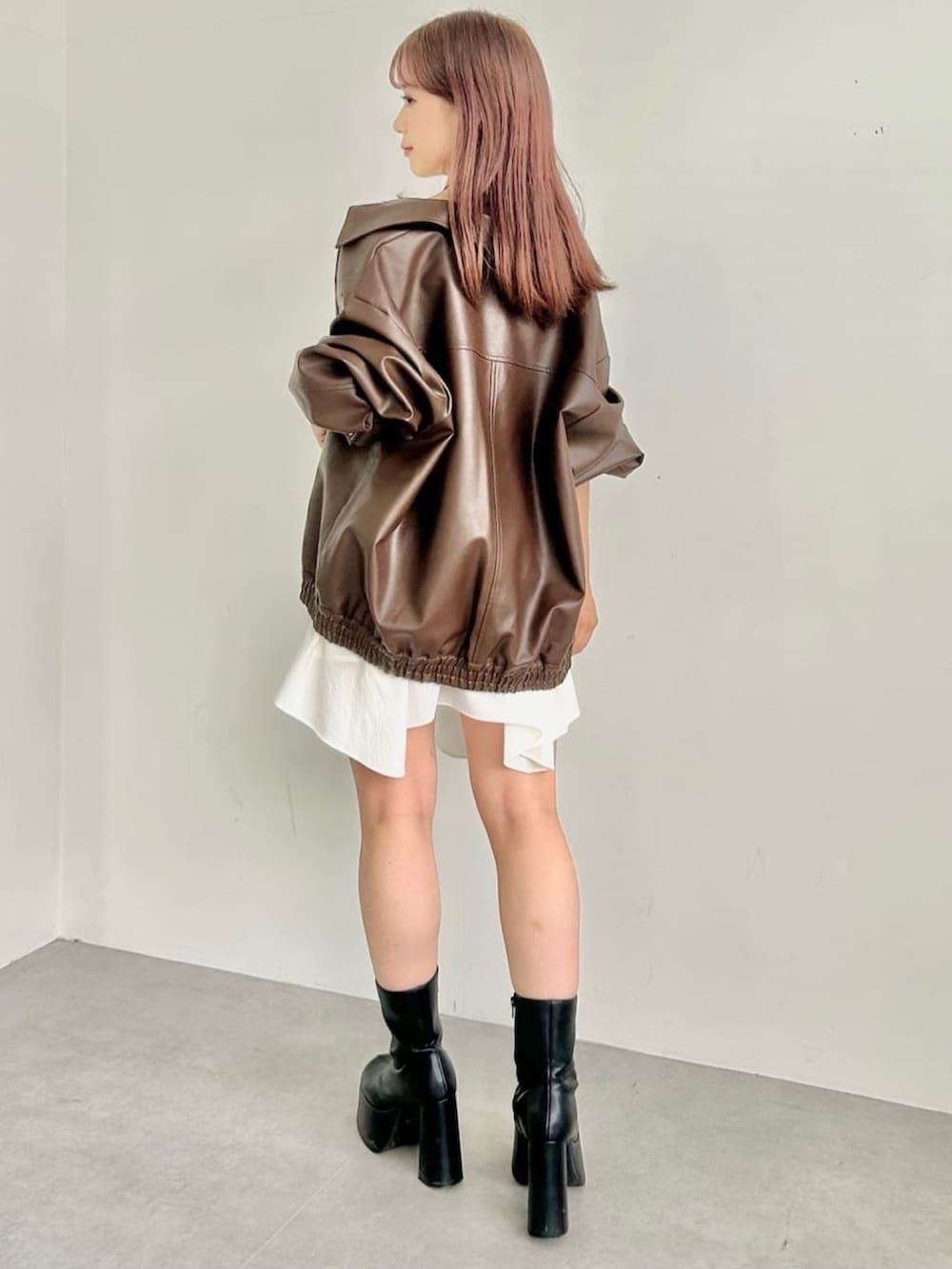 ブラウン系のブルゾン、ホワイト系のワンピースを着用したレディースの秋コーディネートの3枚目の写真