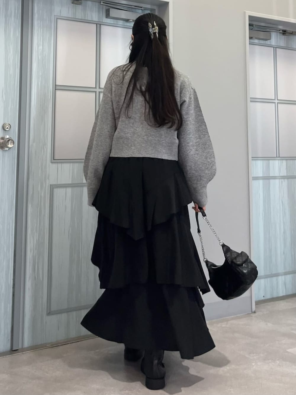 グレー系のカーディガン/ボレロ、ブラック系のスカートを着用したレディースの冬コーディネートの3枚目の写真