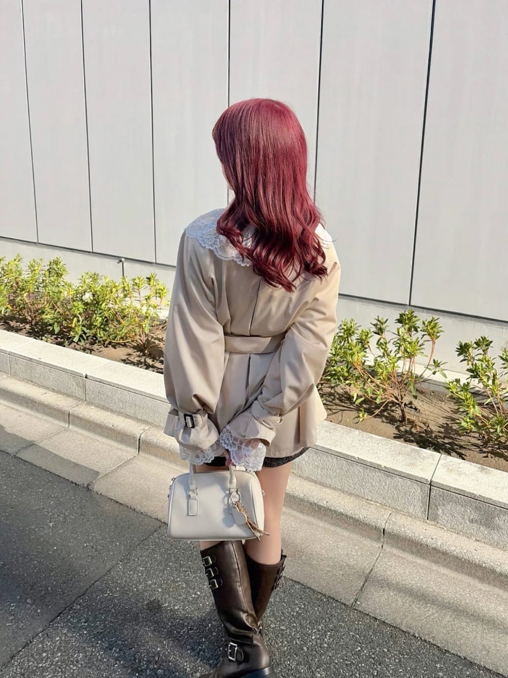 ベージュ系のトレンチコート、ブラウン系のブーツを着用したレディースの冬コーディネートの3枚目の写真