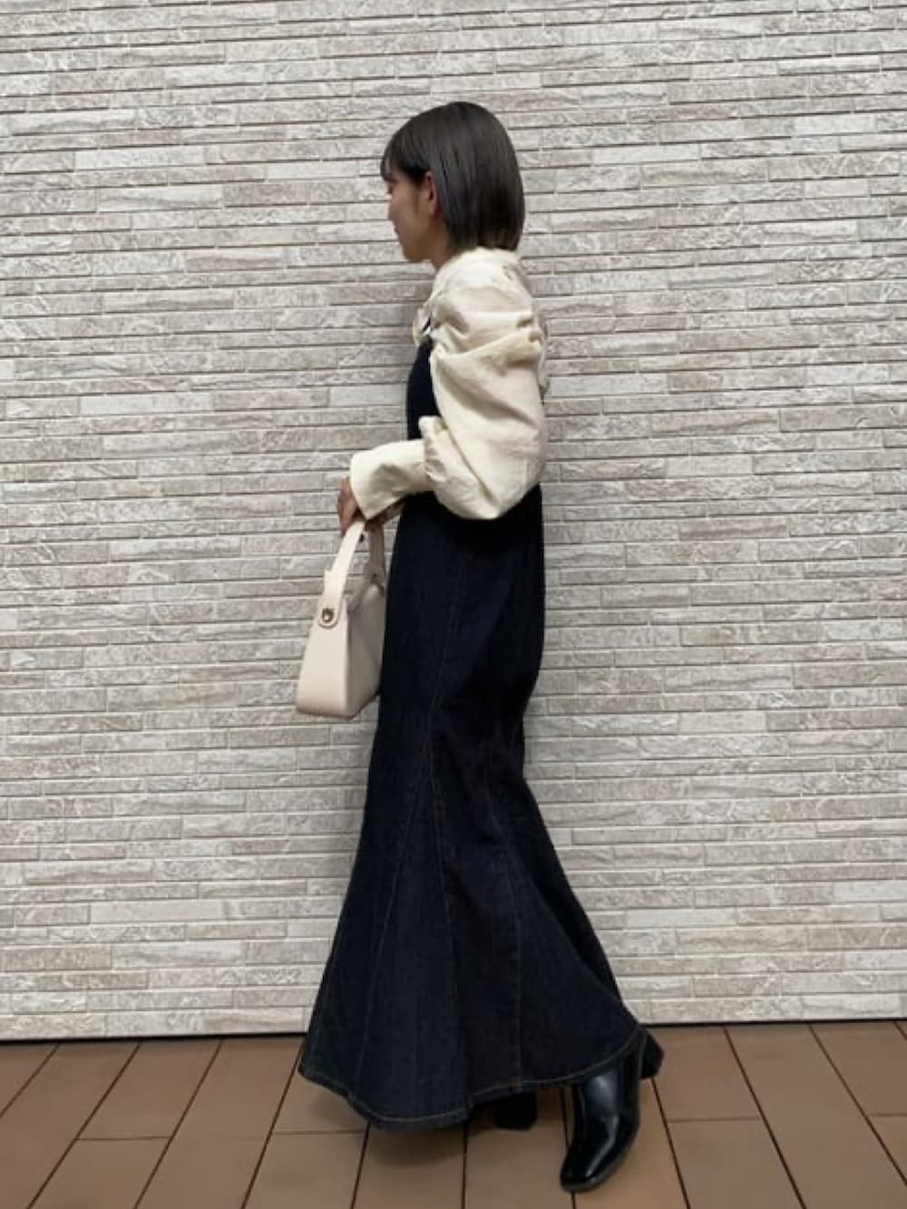 ブラック系のワンピース、ホワイト系のシャツ/ブラウス、ホワイト系のハンドバッグを着用したレディースの春コーディネートの2枚目の写真