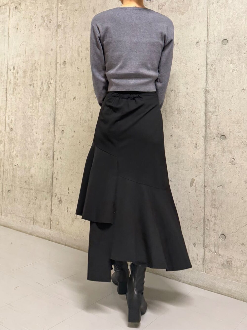 グレー系のニット/セーター、ブラック系のスカートを着用したレディースの冬コーディネートの2枚目の写真