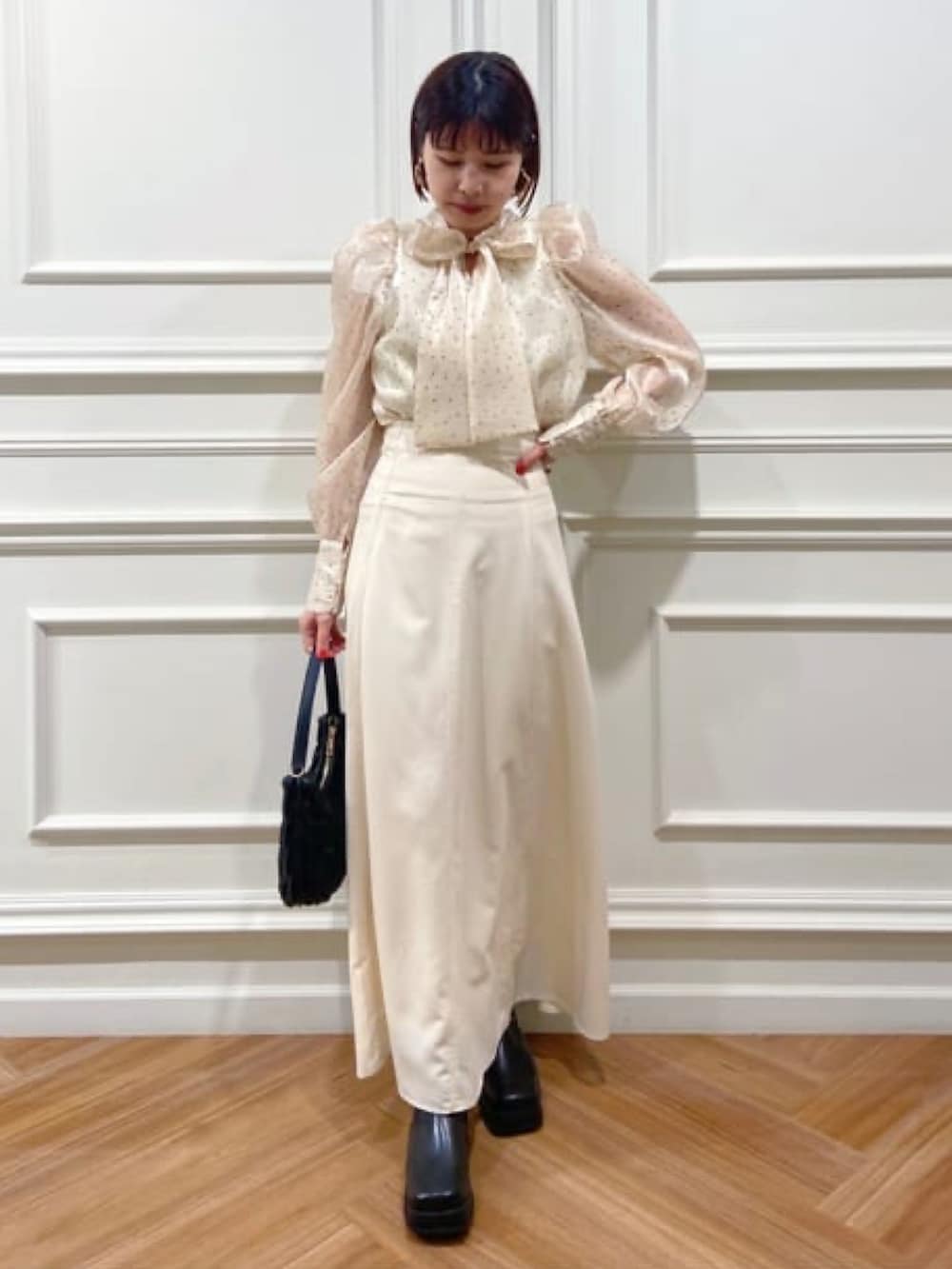 ホワイト系のシャツ/ブラウス、ホワイト系のスカート、ブラック系のハンドバッグを着用したレディースの冬コーディネートの3枚目の写真