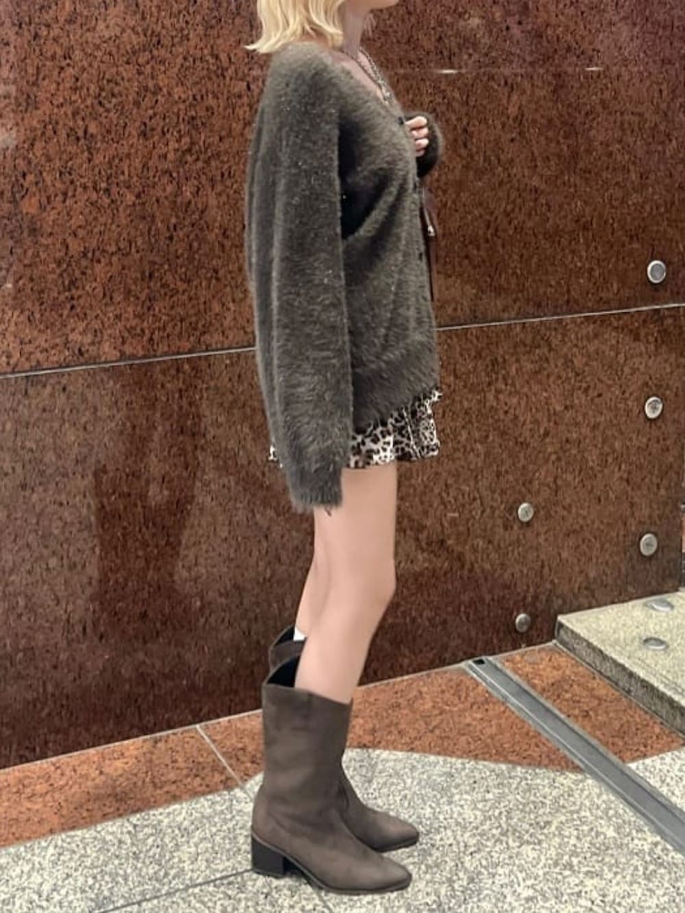 ブラウン系のニット/セーター、ブラウン系のスカート、ブラウン系のブーツを着用したレディースの秋コーディネートの2枚目の写真