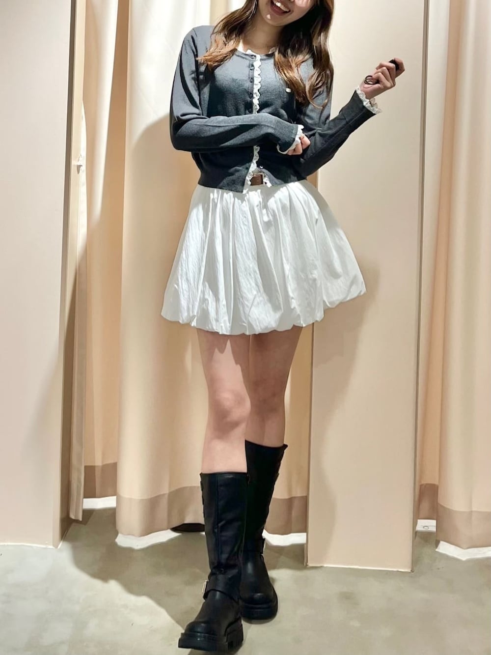 グレー系のニット/セーター、ホワイト系のスカートを着用したレディースの春コーディネートの3枚目の写真