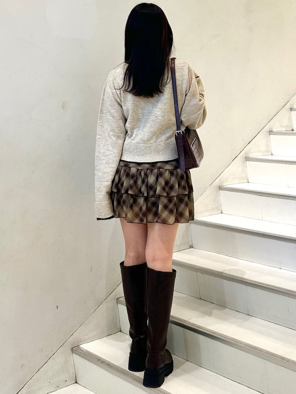 ブラウン系のアンサンブル、ブルー系のスカートを着用したレディースの秋コーディネートの2枚目の写真