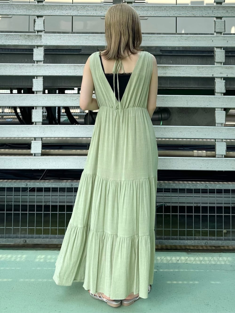 グリーン系のワンピース、ホワイト系のサンダルを着用したレディースの夏コーディネートの2枚目の写真