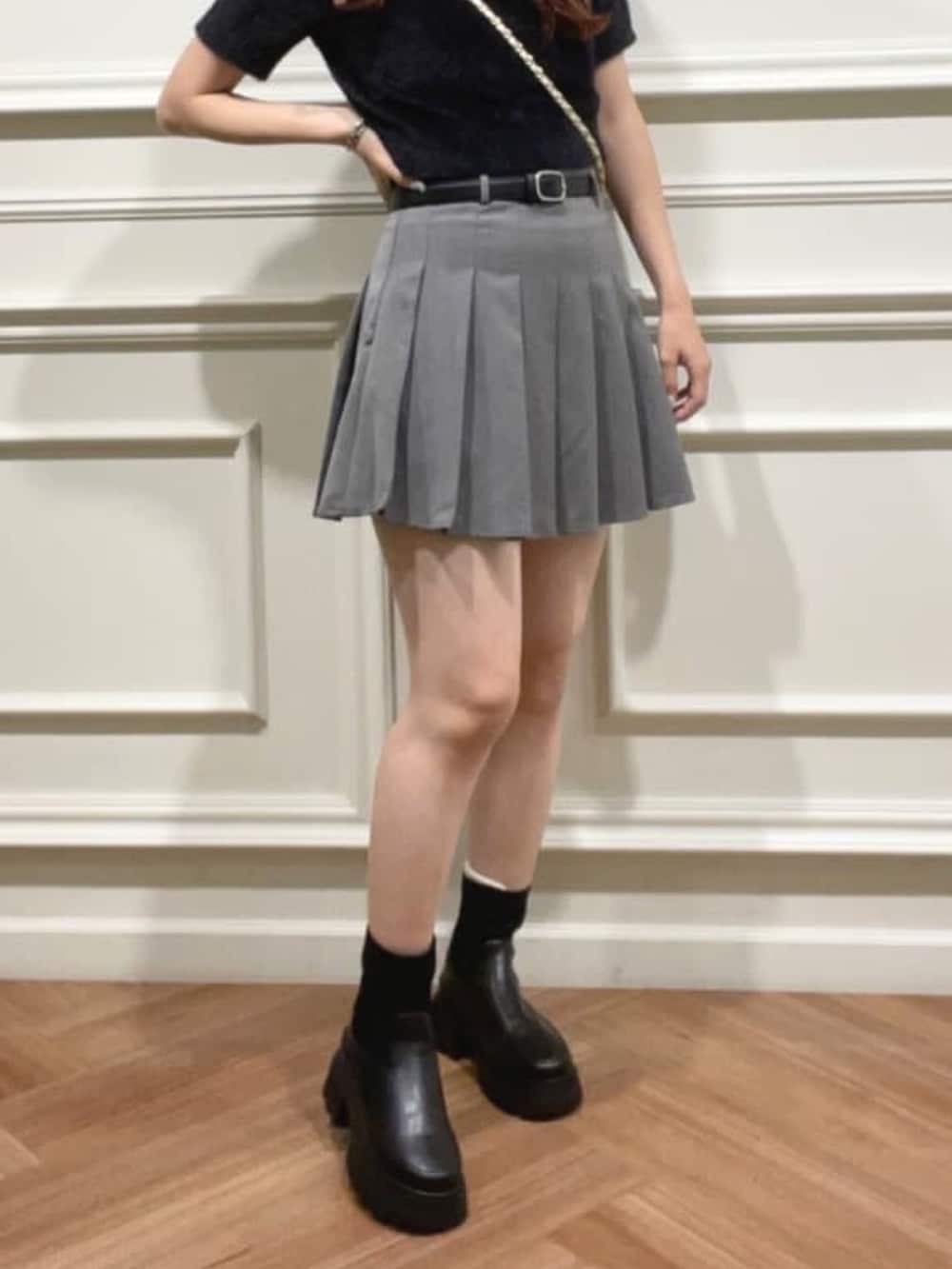 ブラック系のニット/セーター、グレー系のスカート、ホワイト系のショルダーバッグを着用したレディースの夏コーディネートの2枚目の写真