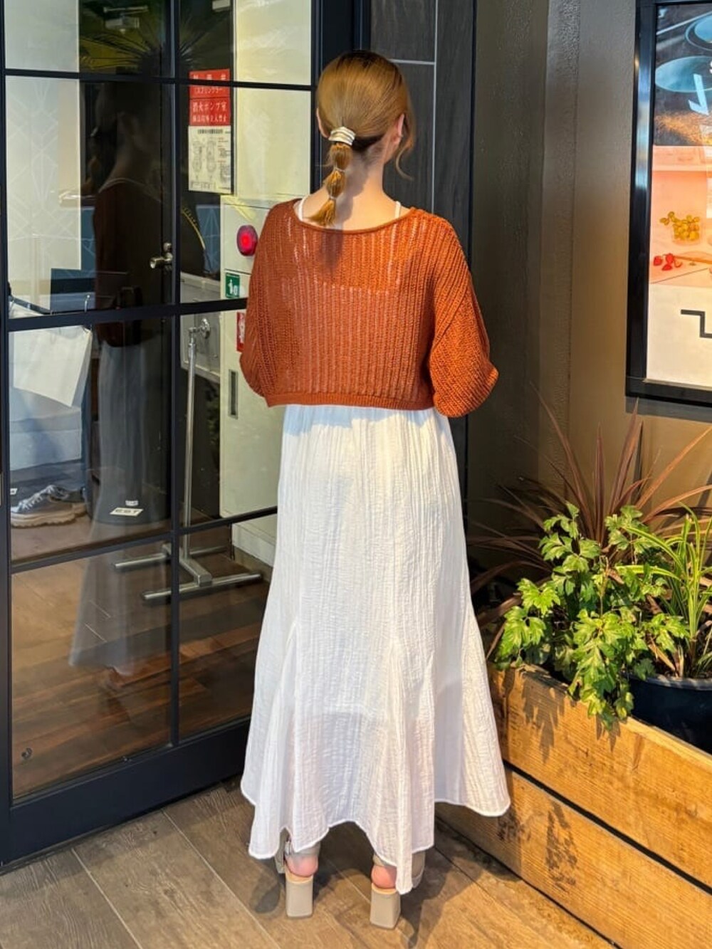 オレンジ系のワンピース、ホワイト系のサンダルを着用したレディースの夏コーディネートの2枚目の写真