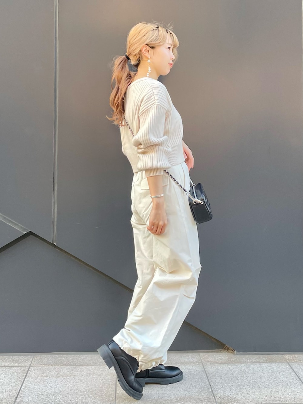 ホワイト系のカーディガン/ボレロ、ホワイト系のカーゴパンツ、ブラック系のショルダーバッグを着用したレディースの冬コーディネートの2枚目の写真