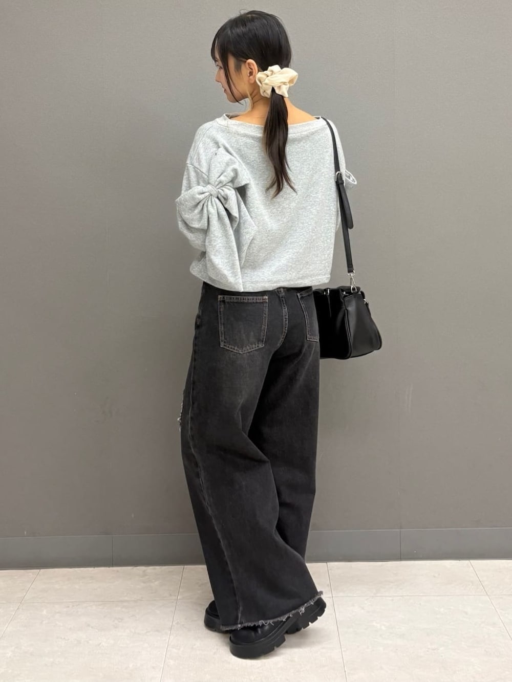 グレー系のTシャツ/カットソー、ブラック系のデニムパンツ、ブラック系のショルダーバッグを着用したレディースの秋コーディネートの3枚目の写真
