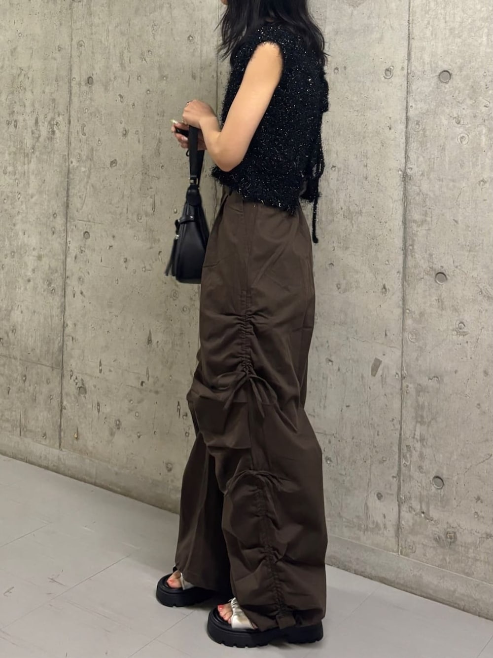 ブラック系のベスト、ブラウン系のカーゴパンツを着用したレディースの夏コーディネートの2枚目の写真