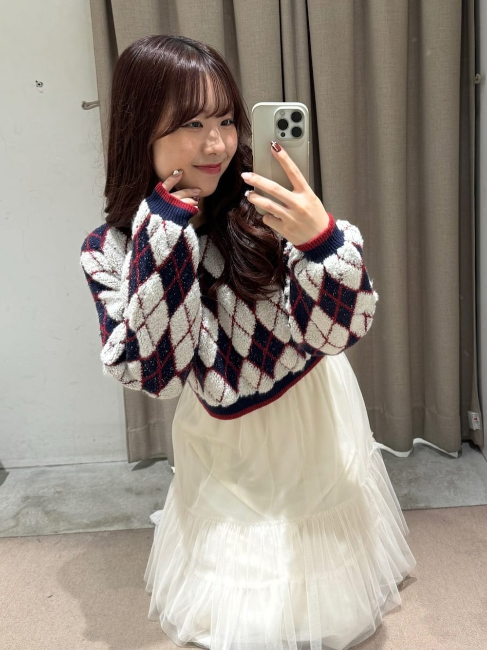 ブルー系のニット/セーター、ブラック系のボストンバッグ、ホワイト系のスカートを着用したレディースの冬コーディネートの3枚目の写真