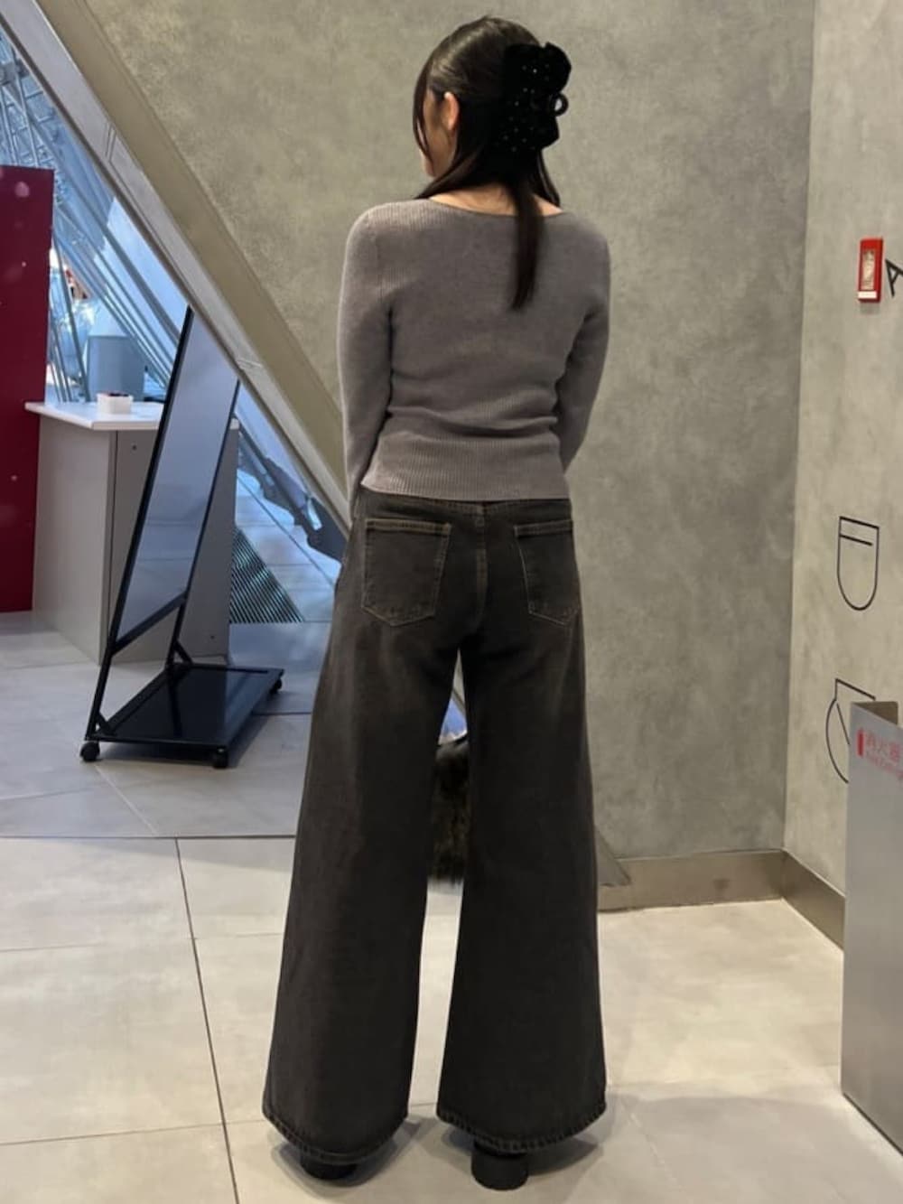 グレー系のニット/セーター、ブラック系のデニムパンツを着用したレディースの冬コーディネートの3枚目の写真