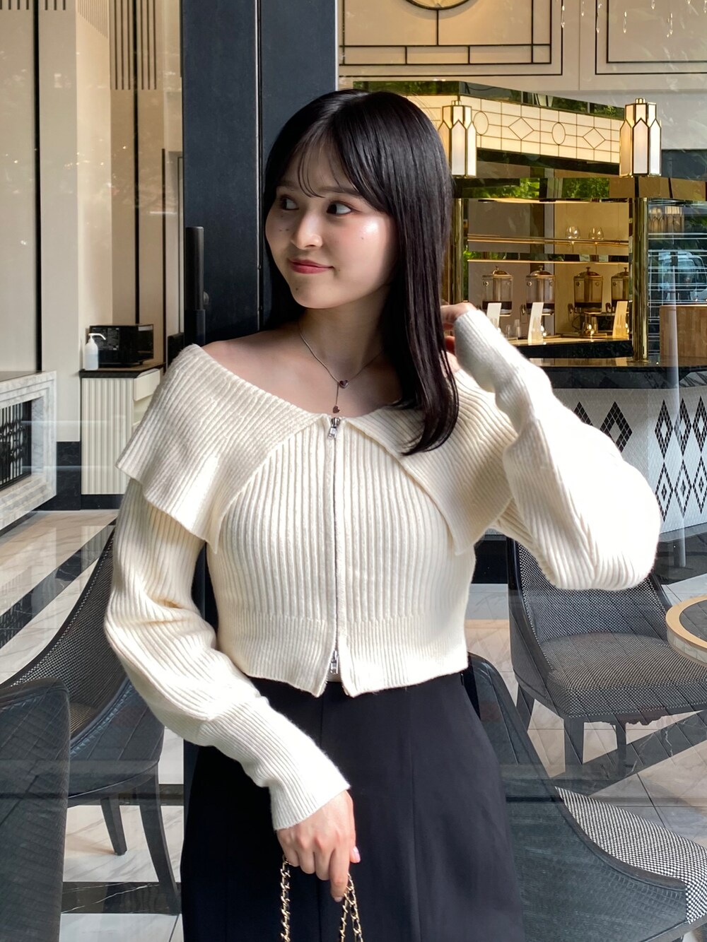 ホワイト系のニット/セーター、ブラック系のスカートを着用したレディースの秋コーディネートの2枚目の写真