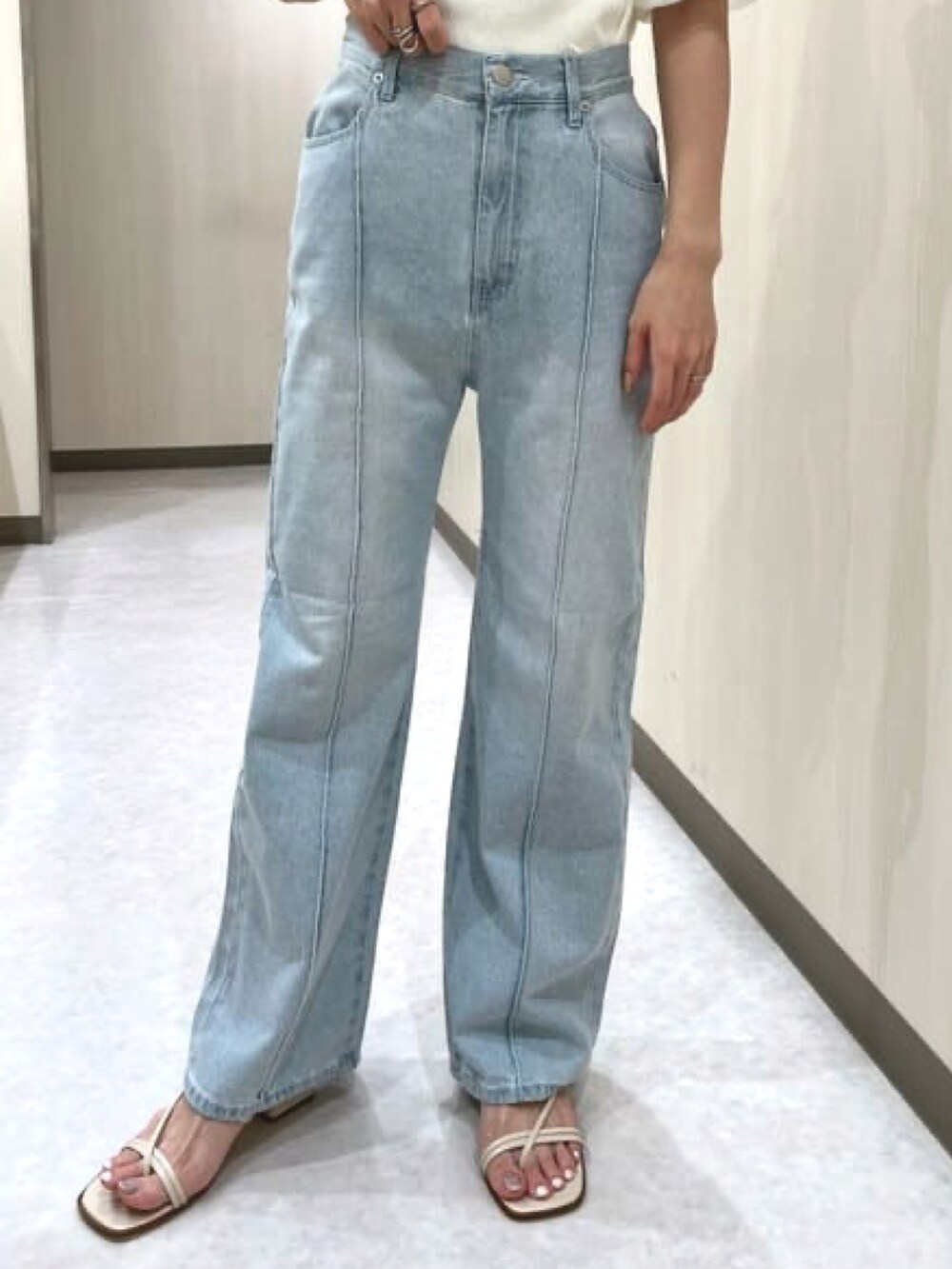 ホワイト系のニット/セーター、ブルー系のデニムパンツ、ホワイト系のサンダルを着用したレディースの春コーディネートの4枚目の写真