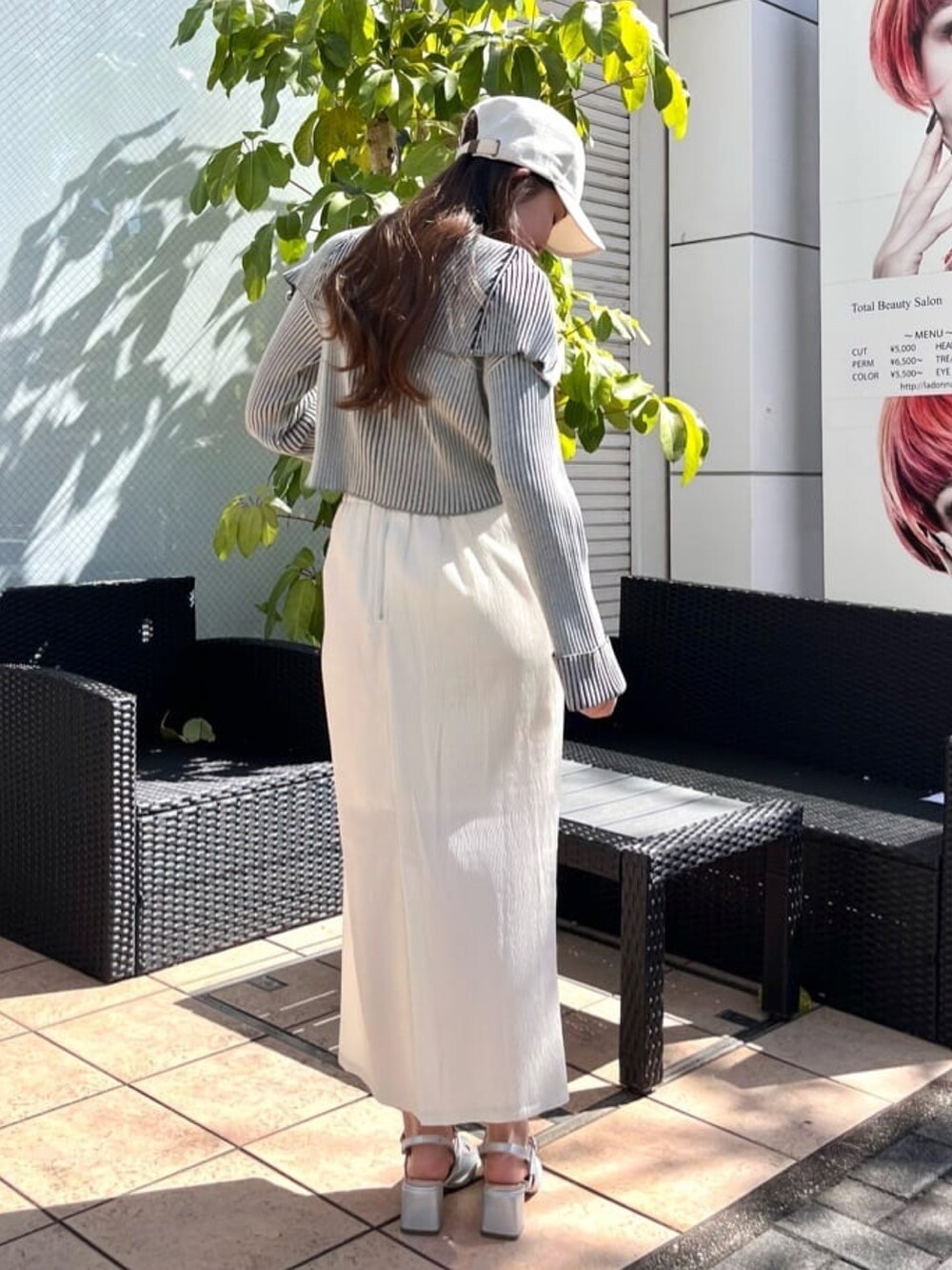 ホワイト系のスカート、グレー系のパンプス、ブルー系のニット/セーターを着用したレディースの春コーディネートの2枚目の写真